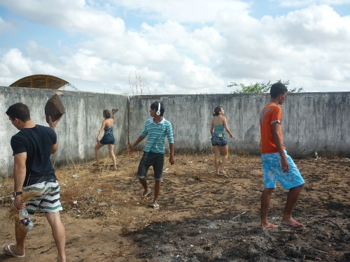 Retirada das pedras e dos garranchos do terreno fora da quadra